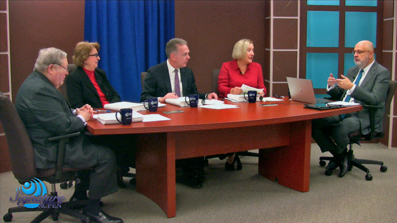 Screen capture from a live webcast production showing a panel of people in discussion